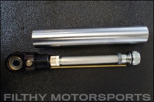 Closeup photo of an ORI STX Strut rebound shaft next to shaft cylinder
