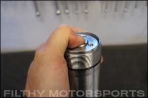 Closeup photo of an ORI STX Strut shaft with bump stop piston compressed by a thumb