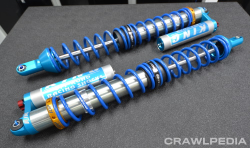 two King coilover shocks with springs and reservoirs on a table