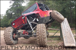 A photo of a red Jeep articulating with ORI STX struts installed