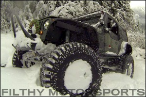 A black leep driving through deep snow with ORI STX struts installed